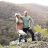 Pár muž a žena na turistike na horách. Majú na sebe merino tričká Summit od značky kallys v hnedej a mentolovej farbe. Pozerajú sa na seba.